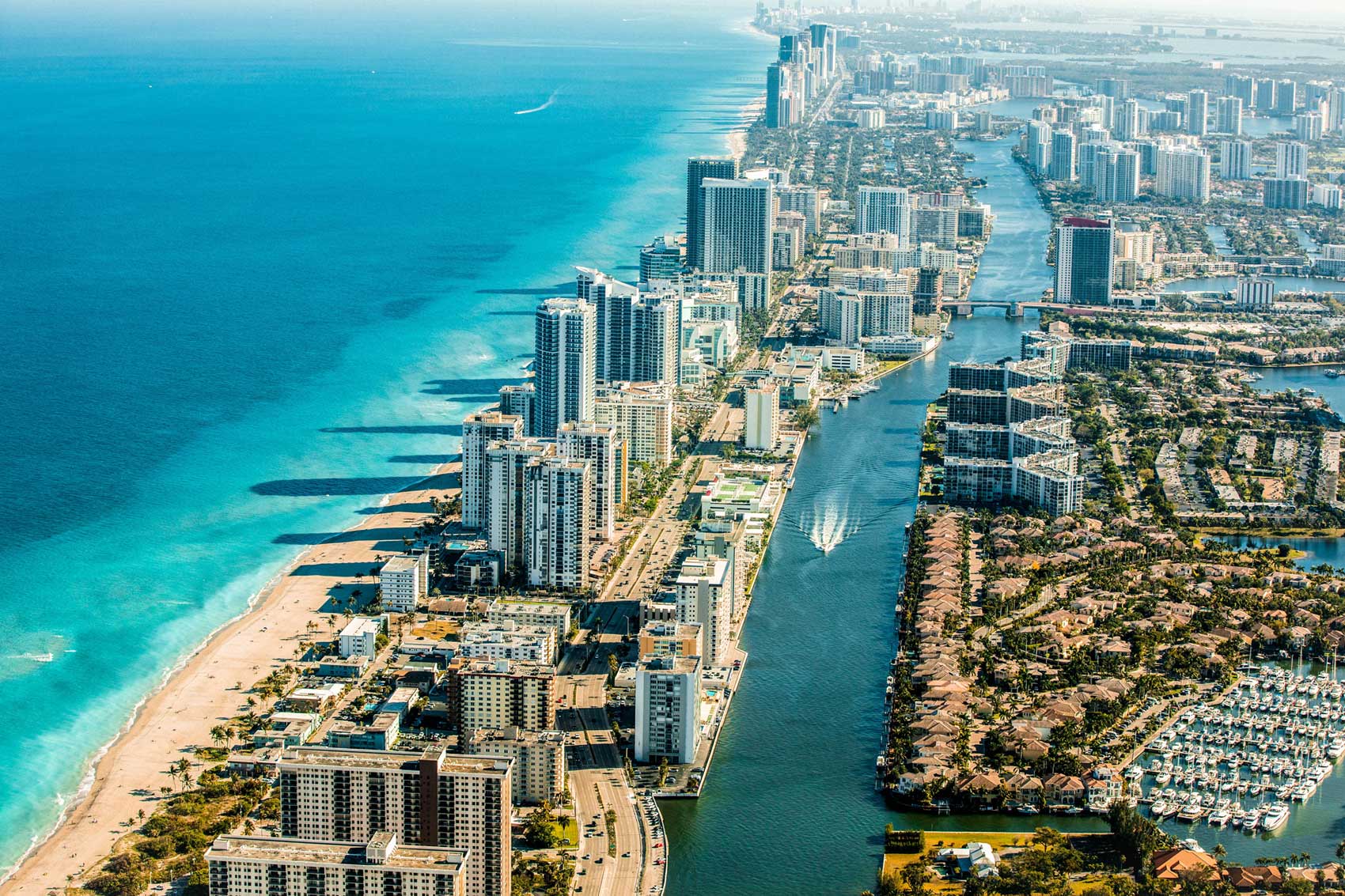 aerial view of florida beach and river lined by apartment buildings